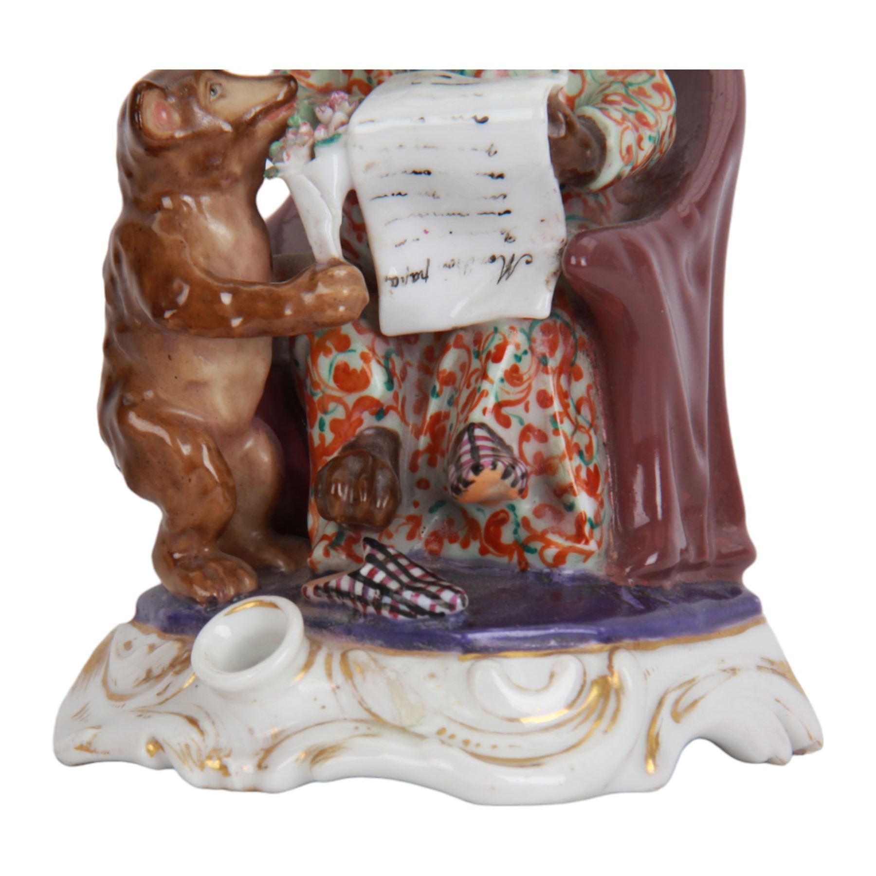 Mid 19th century French porcelain inkwell, possibly Jacob Petit, circa 1884, modelled as a anthropomorphic bear seated within an armchair, wearing cap, gown and slippers, reading a letter to a small cub holding a bunch of flowers, upon a shaped and scrolling base, impressed and incised marks beneath, H19cm
