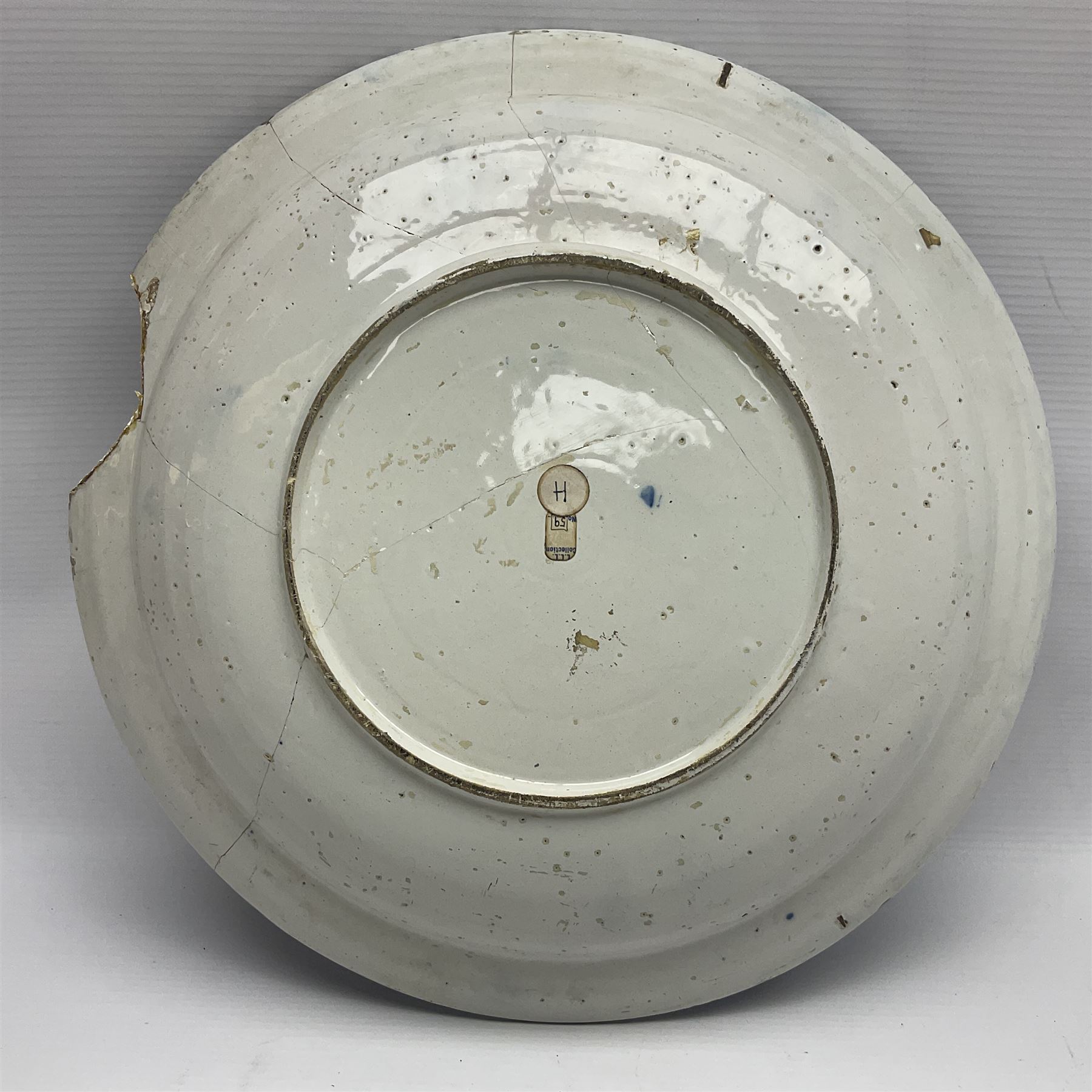 Early 18th century Delft marriage plate, of circular form with dished centre, the centre inscribed and dated 'Thomas and Elizabeth Kockerill Bridlington Key 1715' within a crowned C scroll cartouche, flanked by demi-griffins, above a putto head and tassels, within a wide foliate border, D34cm
