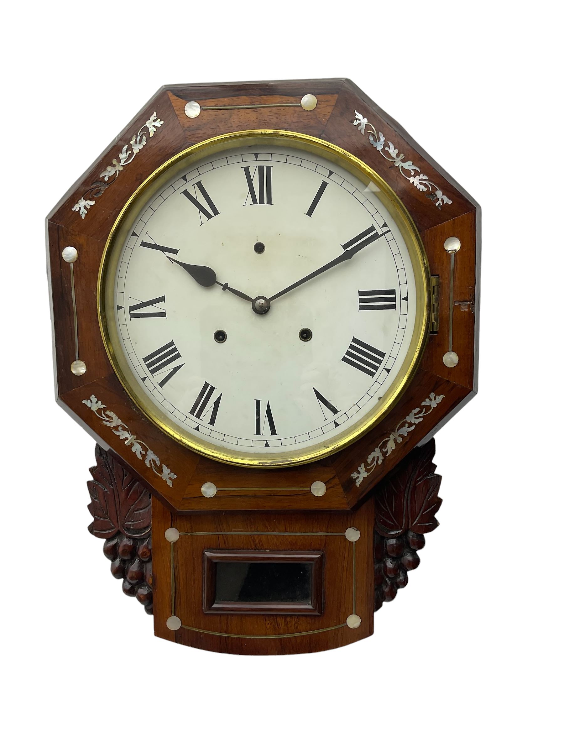 American - late 19th century 8-day mahogany drop dial wall clock, with a hexagonal dial bezel inlaid with mother of pearl, pendulum box with a rectangular viewing glass flanked by carved representations of grape vines, with a painted dial with roman numerals, minute track and steel spade hands within a spun brass bezel, eight day striking movement striking the hours on a gong.   With pendulum & key.