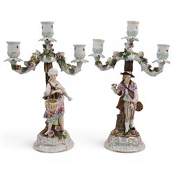 Pair of 19th Century German three-branch figural candlesticks, the figures each in floral ...