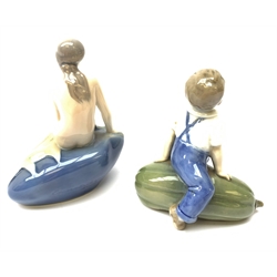  A Royal Copenhagen figurine, modelled as a mermaid, H13.5cm, together with another figure modelled as a boy seated upon marrow, H12cm, each with printed and painted marks to base.   
