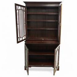 Early 20th century Chippendale design mahogany bookcase, projecting moulded cornice over four astragal glazed doors, the interior fitted with adjustable shelves, on bracket feet 