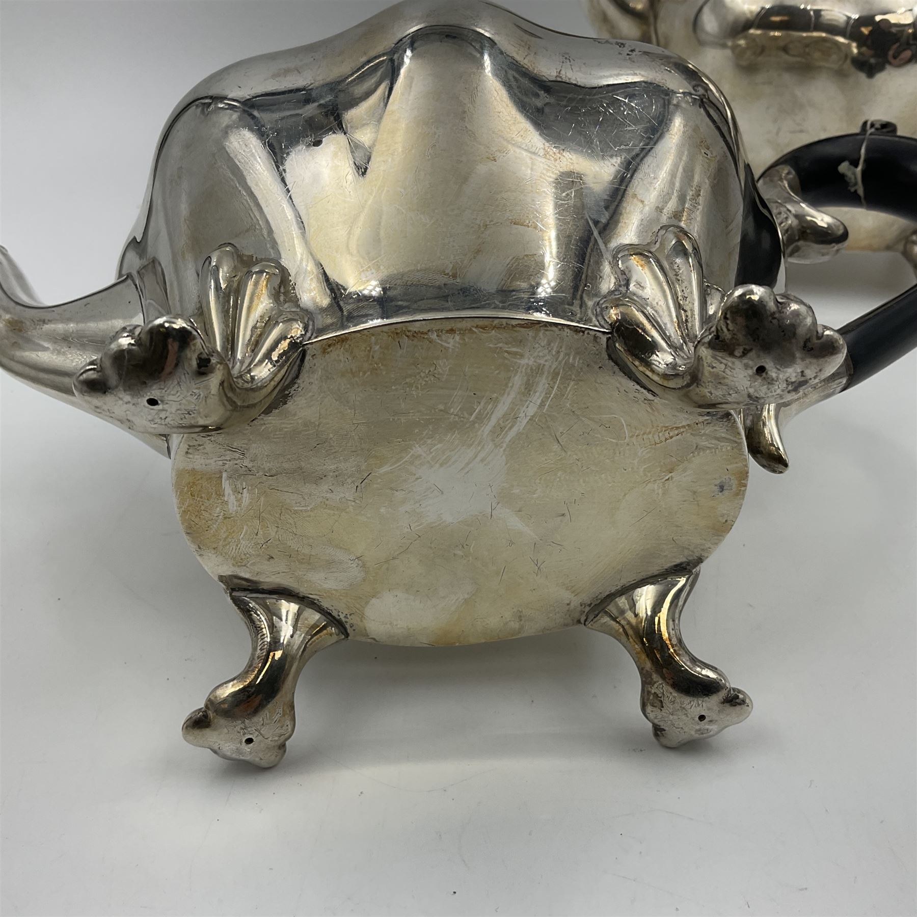 Five piece Edwardian silver tea service, comprising teapot and coffee pot, each with ebonised scroll handle, tea caddy with hinged cover, twin handled open sucrier, and milk jug, each of rounded bombe form, upon four paw feet, hallmarked William Adams Ltd, Birmingham 1904 and 1905, coffee pot H26cm
