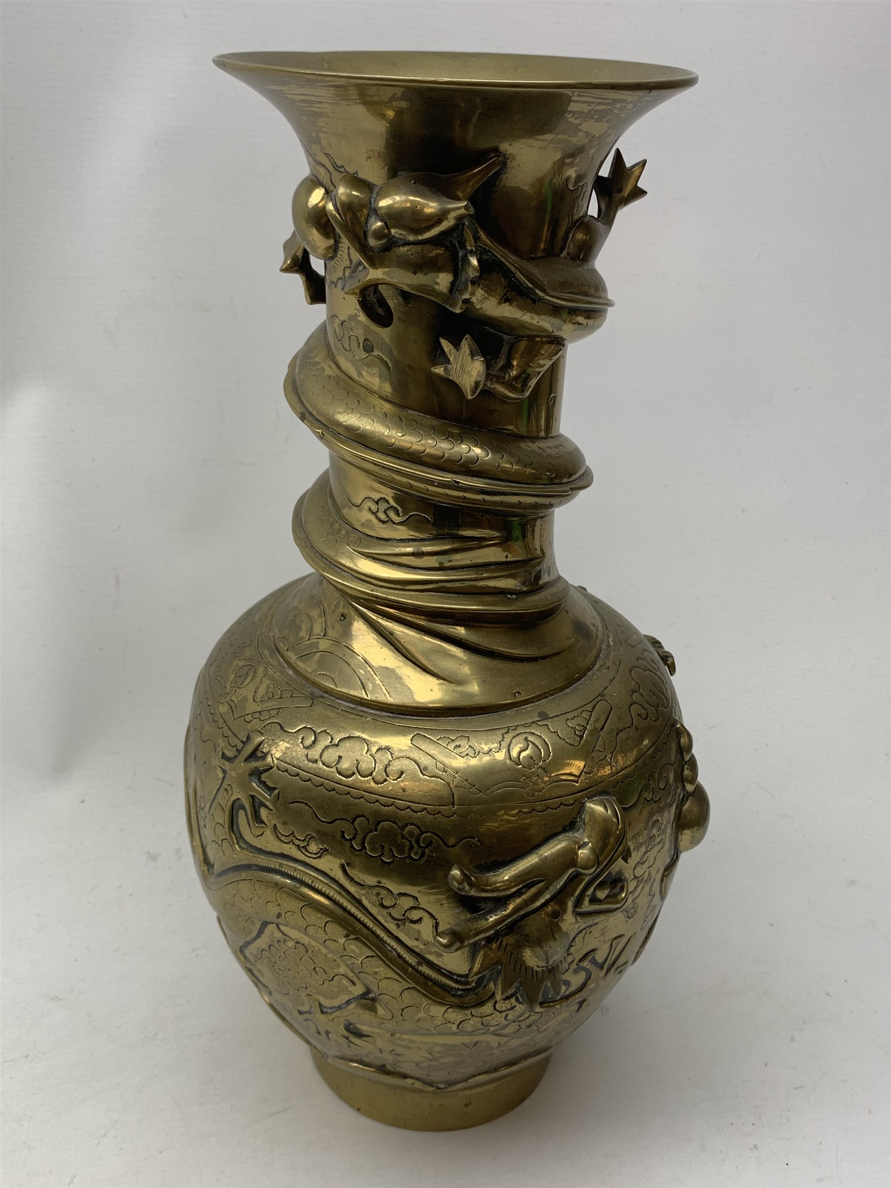 A large Chinese brass vase, of ovoid form with tall neck and flared rim, decorated in relief with dragons chasing a flaming pearl, and further incised with clouds and other detail, the base with relief dragon detail and character mark, H41