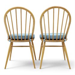 Ercol - pair of 'Windsor' dining chairs, with high hooped back, blue seat cushions with studded, tapered supports  