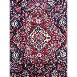Persian Hamadan indigo ground carpet, the field decorated with central rectangle and outer band, overall floral pattern with cusped central medallion and surrounding leafy branches with palmettes, the border with scrolling branches decorated with further palmettes, within floral pattern guard stripes