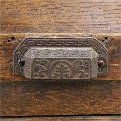 18th century rustic oak dresser base, with fielded panels and iron cup handles with embossed greek key and foliate detail, three short drawers above and open recess flanked by two cupboard doors, raised on stile supports