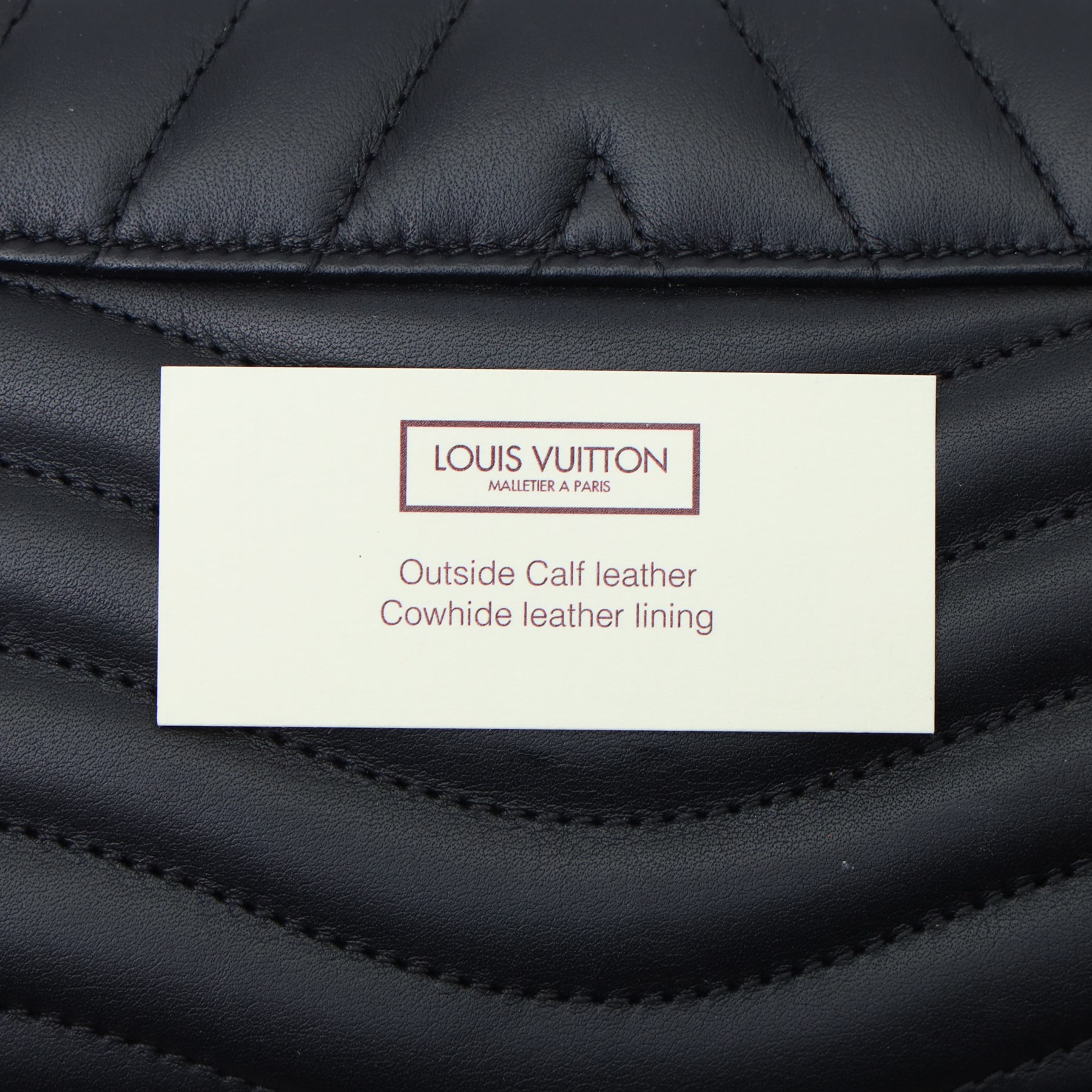 Louis Vuitton - ‘New Wave’ Long Wallet in black quilted calf leather, the envelope flap with oversized gold-tone LV logo and press-stud fastening, with detachable wrist strap detailed in multicoloured Louis lettering and Monogram flowers, opening to a fitted leather interior with twelve card slots, two compartments and zipped pocket, with care booklet and box