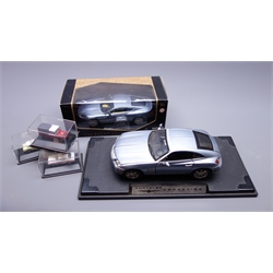  Motor Max large scale die-cast showroom display model of a Chrysler Crossfire on titled plastic stand L35cm, Motor Max large scale die-cast model of an Aston Martin DB9 Coupe in window box, and three Oxford HO scale die-cast models of Ford Anglia, Land Rover and Police Car, all in perspex display boxes (5)  
