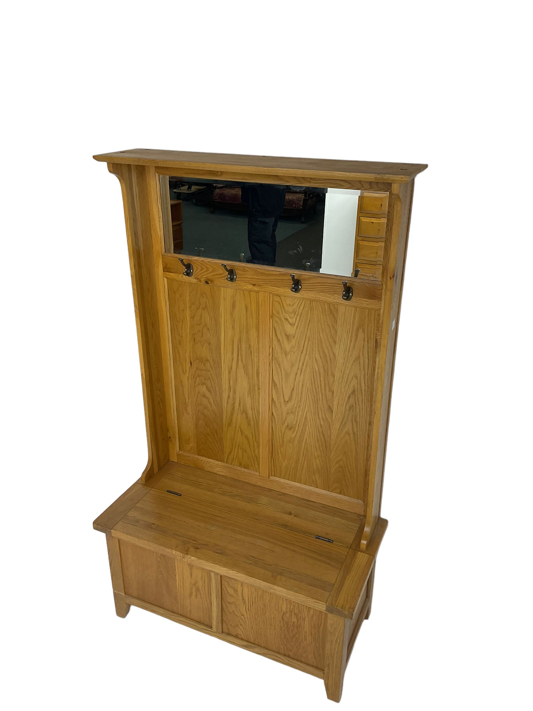 Oak mirror-back hall bench, projecting cornice, rectangular bevelled plate over four coat hooks, hinged box seat compartment with panelled front, on square tapering feet