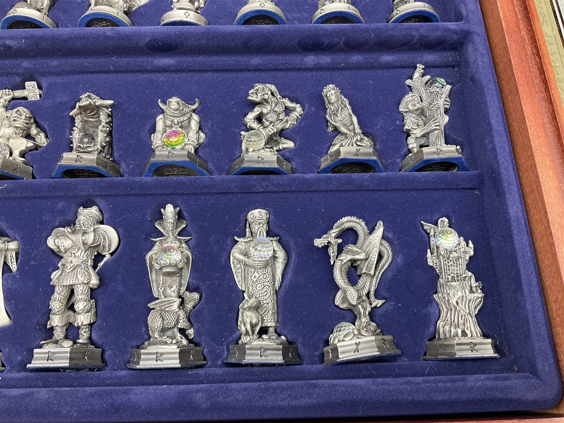 Danbury Mint 'The Fantasy of the Crystal' chess set consisting of mythical pewter chess pieces within a wooden case with chess board lid, together with 16 additional chess pieces in a wooden display case.