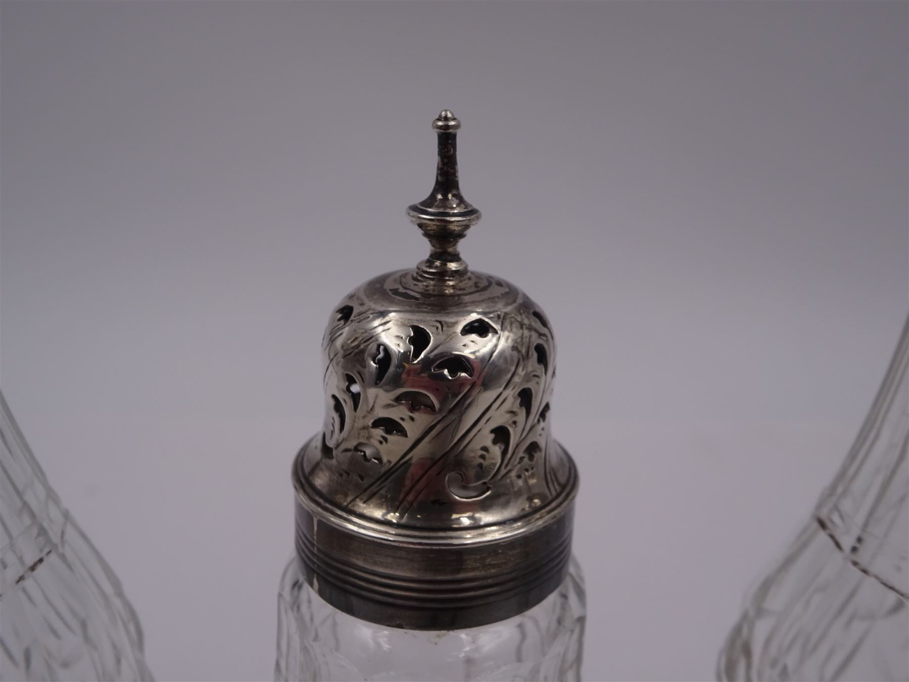 Late 18th century silver cruet stand, of oval form, with pierced sides upon four bun feet, hallmarked to handle Hester Bateman, all other hallmarks indistinct, together with five matched silver mounted cut glass cruet bottles, including some later Victorian examples, hallmarks predominantly indistinct, stand H20cm