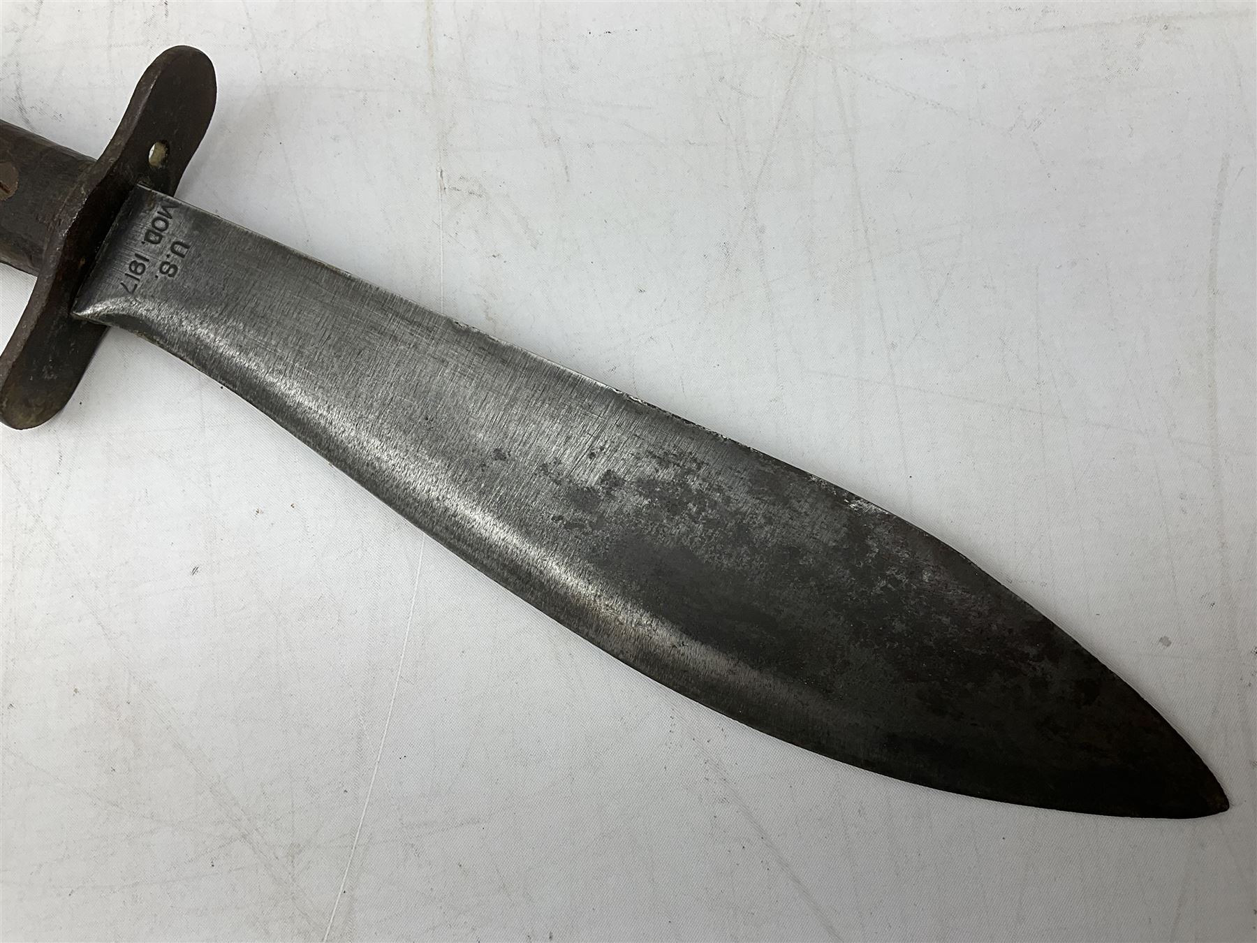 US Model 1910/17  Machine Gunners Bolo knife, the 26.5cm curving steel blade marked 'US MOD 1917 PLUME PHILA 1918'; in webbing covered steel scabbard with leather chape marked 'Brauer Bros 1918' L40.5cm overall (with photocopy of modern reference material)