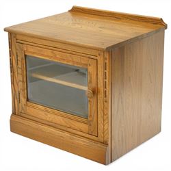 Ercol - elm media cabinet of small proportions, fitted with glazed door enclosing single s...