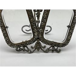 Early 19th century silver plated double photograph frame, each rounded rectangular aperture surrounded by a paste border, with ornate scroll feet and mantling also set with clear paste stones, with easel style support verso, H12cm