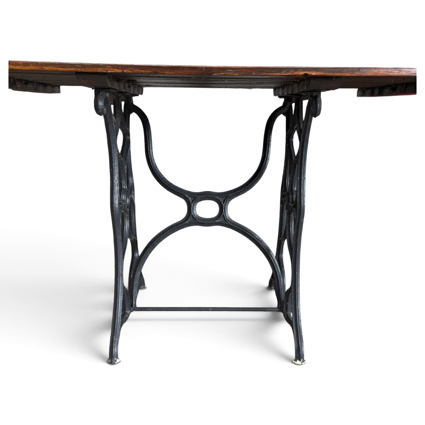 Antique rectangular slatted hardwood garden table, raised on pierced black painted cast iron supports cast with scrolling branchwork and united by pierced curved X-stretcher
