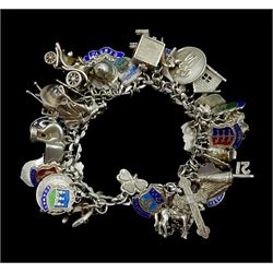 Silver charm bracelet with a large selection of silver charms including car, policeman, elephant, record player etc