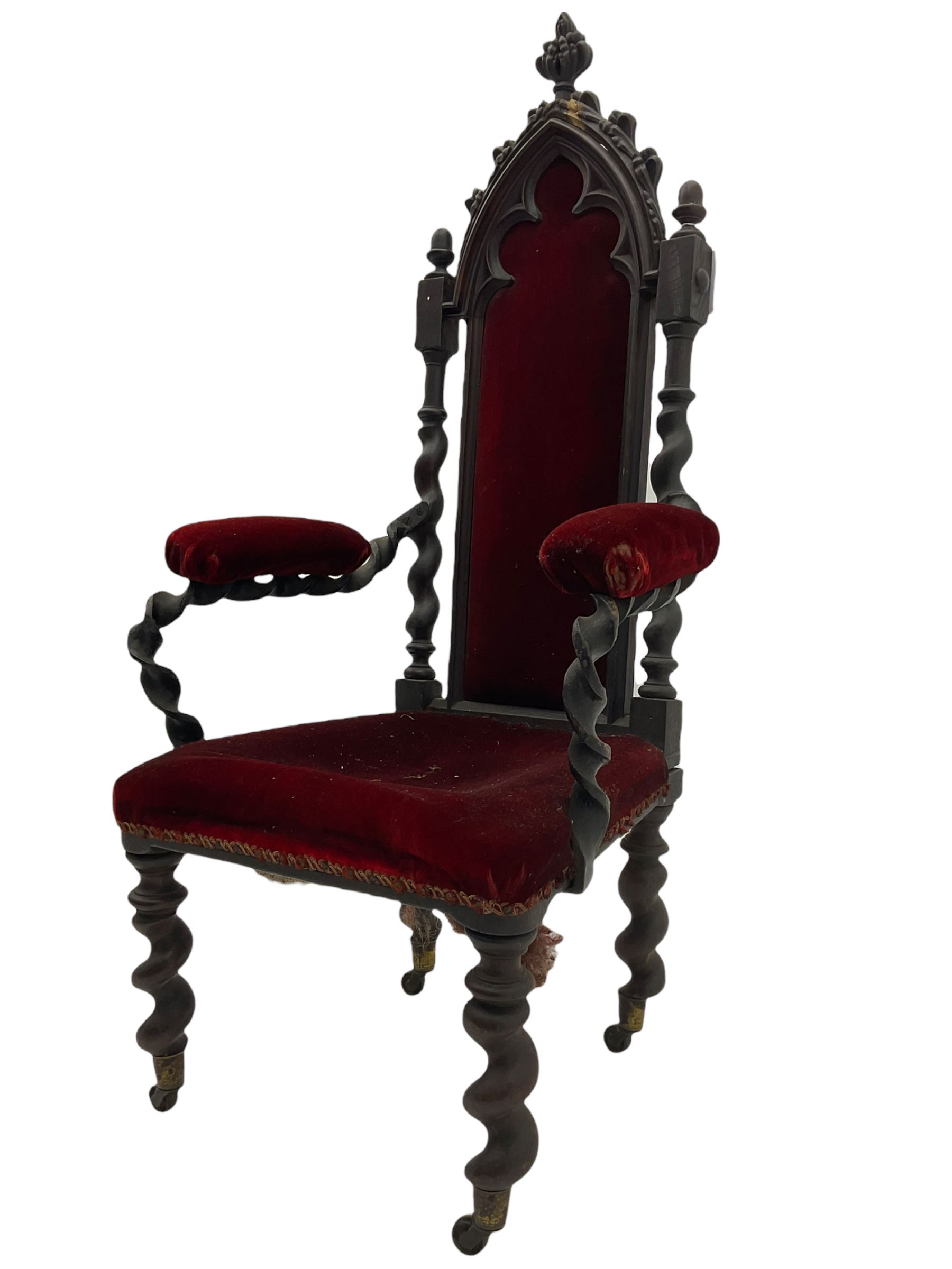 Victorian oak and wrought metal Gothic open armchair, the pointed arched back carved with foliate, cusped inner arch upholstered in red, spiral turned uprights and supports, with arms made of spiral forged metal