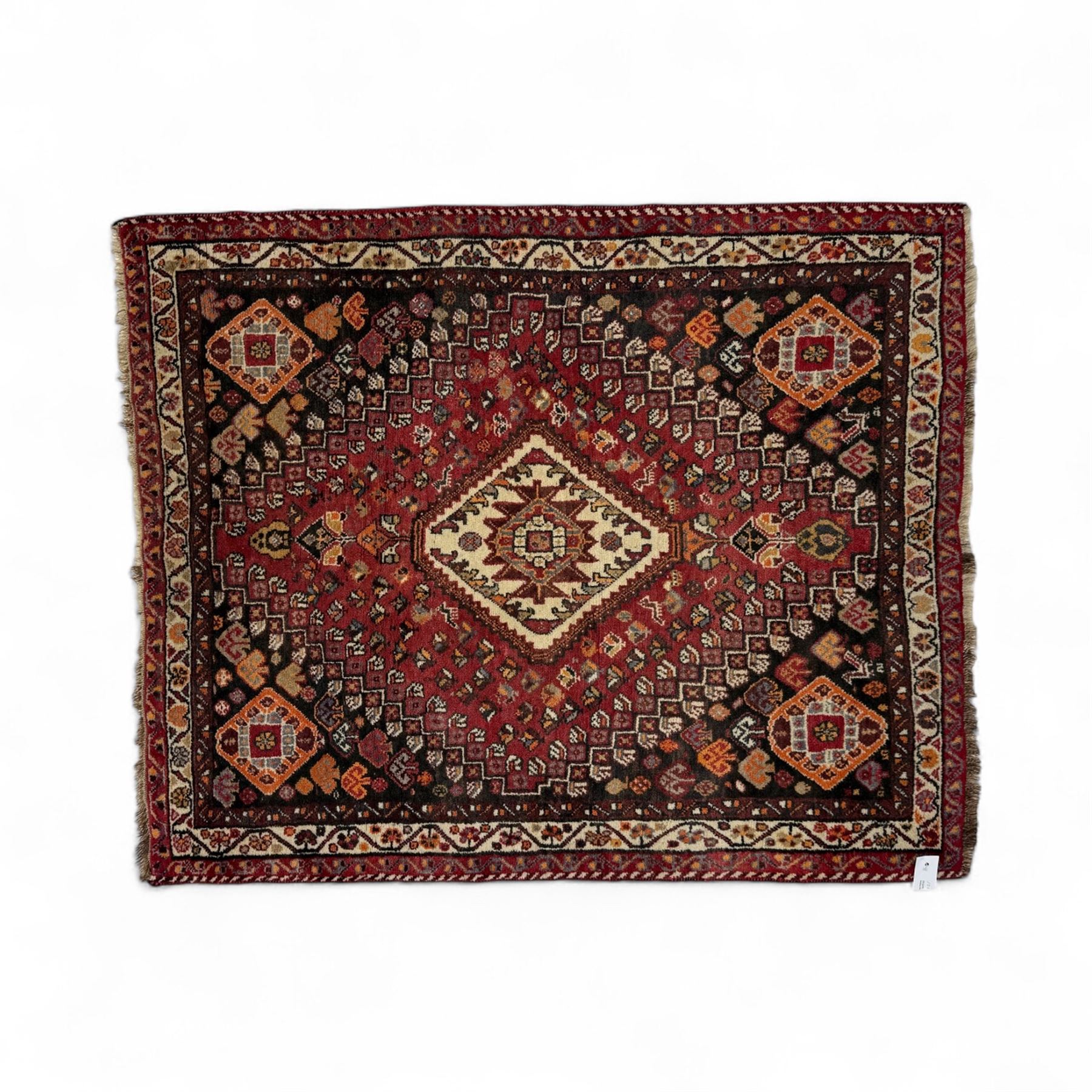 Southwestern Persian Qashqai rug, central diamond medallion with hooked motifs flanked by four corner medallions on a rich red madder field with dark brown ground of stylized floral and animal motifs, and ivory border with alternating floral palmettes and a red main  border with a meandering vine pattern 