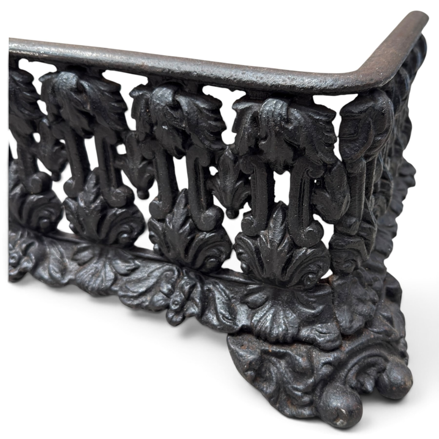 Three cast iron fireplace fittings, comprising a Regency-style fire grate with sunburst crest, urn finials, bowed basket and scroll supports (W58cm H63cm); Victorian fender with pierced acanthus frieze and foliate base (W64cm H20cm); Gothic Revival fireplace with fleur-de-lis crest, arched surround and integral fire basket (W41cm H87cm)