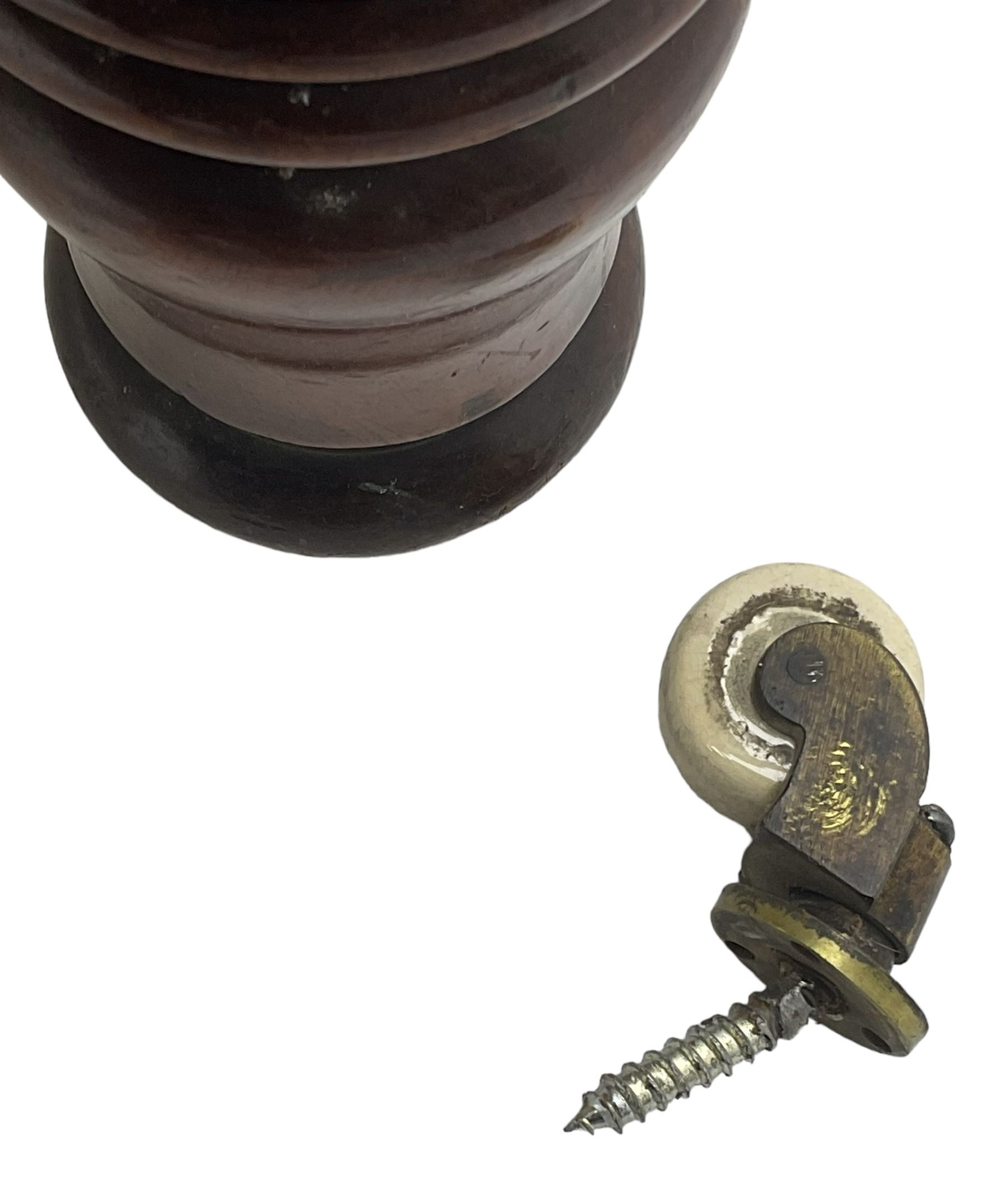 Victorian mahogany framed three-seat settee, upholstered in floral pattern fabric, on turned feet with brass and ceramic castors 