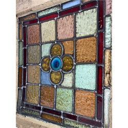Collection of stained glass window, multi-coloured geometric design with central stylised flower head motifs, two smaller windows (50cm x 46cm), and three larger windows (51cm x 69cm)