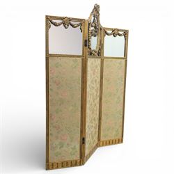 Late 19th century French Louis XIV style giltwood three fold dressing screen, each panel upholstered in floral fabric within fluted borders, with mirrored panels to tops set within moulded frames with foliate and ribbon swags 
