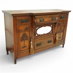 Late 20th century Art Nouveau walnut sideboard, the moulded rectangular top above a run of three drawers, the outer drawers with blind fretwork decoration and applied metal handles, the centre drawer with scroll carved terminals, below a central mirrored cupboard door with oval panel and pierced surround, flanked by carved panel doors with sinuous foliate motifs, on turned supports
