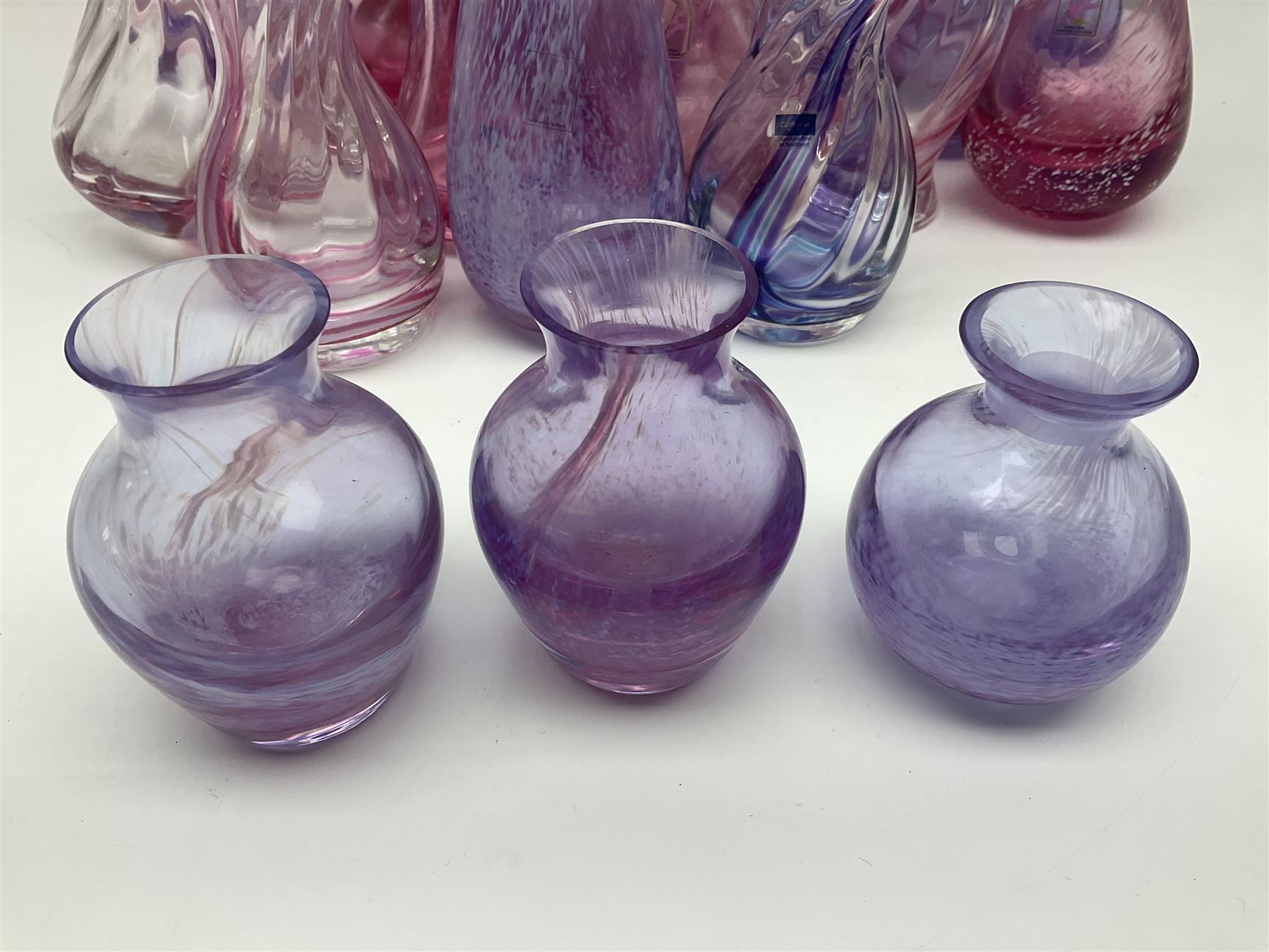 Collection of pink/purple Caithness glass vases, to include mottled and swirl designs, largest 20cm (19)