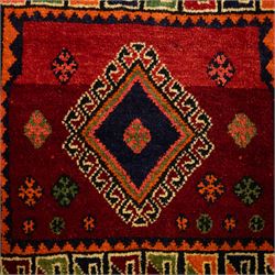 South West Persian Qashgai saddlebag, (Khorjin), woven in geometric designs with central lozenge medallions on a rich madder red ground, decorated with tribal motifs in indigo, ivory green, and ochre, the reverse  with panels of stripped flatwoven kilim 