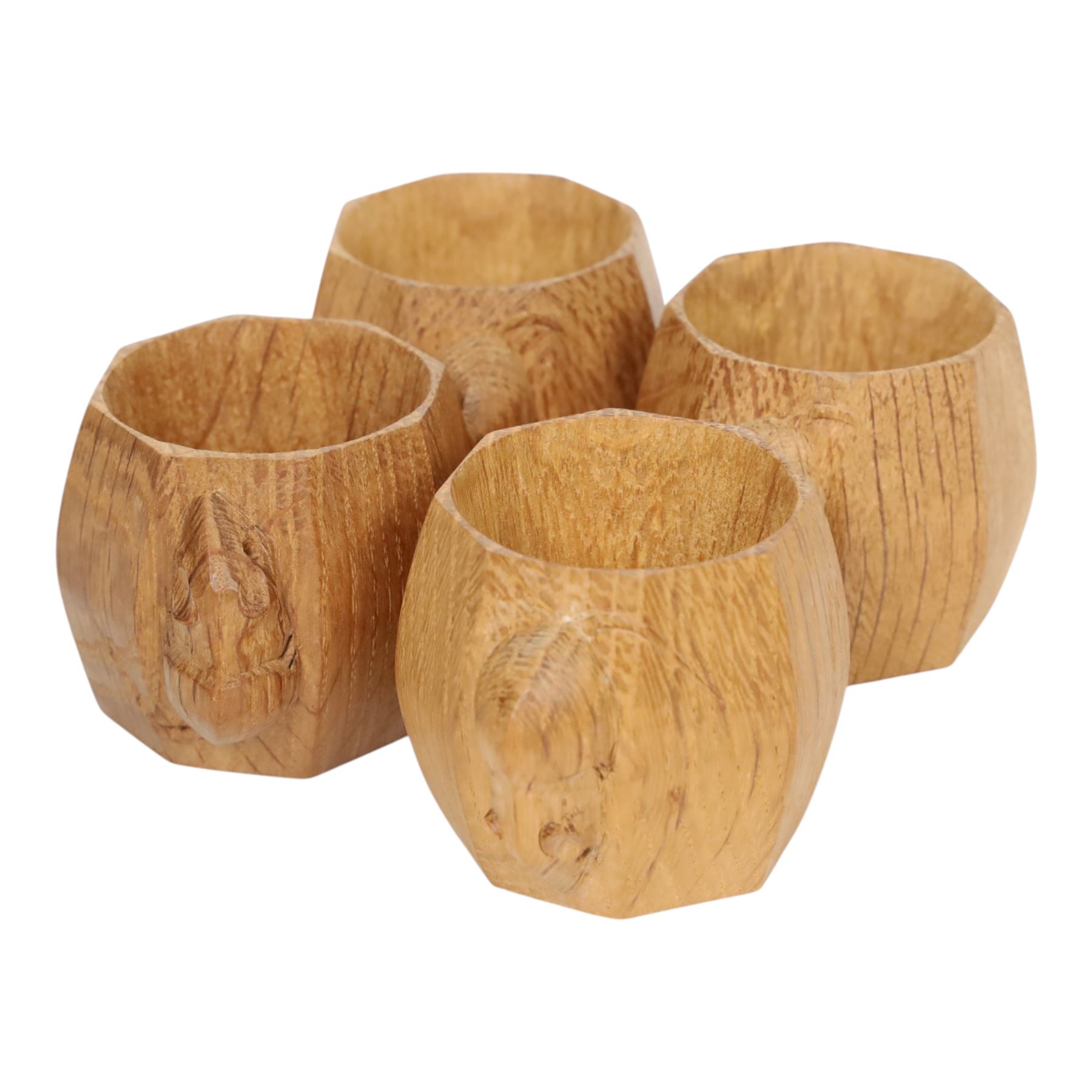 Mouseman - four light oak napkin rings, of bulbous octagonal form with signature mouse carving by Robert Thompson of Kilburn