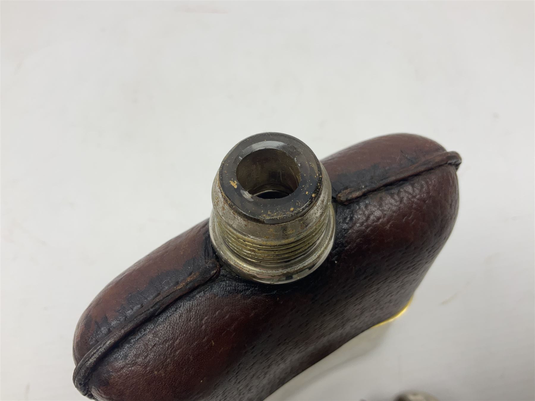 Silver plated glass and pressed leather hip flask, with swivel cap and removable cup, together with a similar oval example, engraved with wreath and initial B, tallest H16.5cm