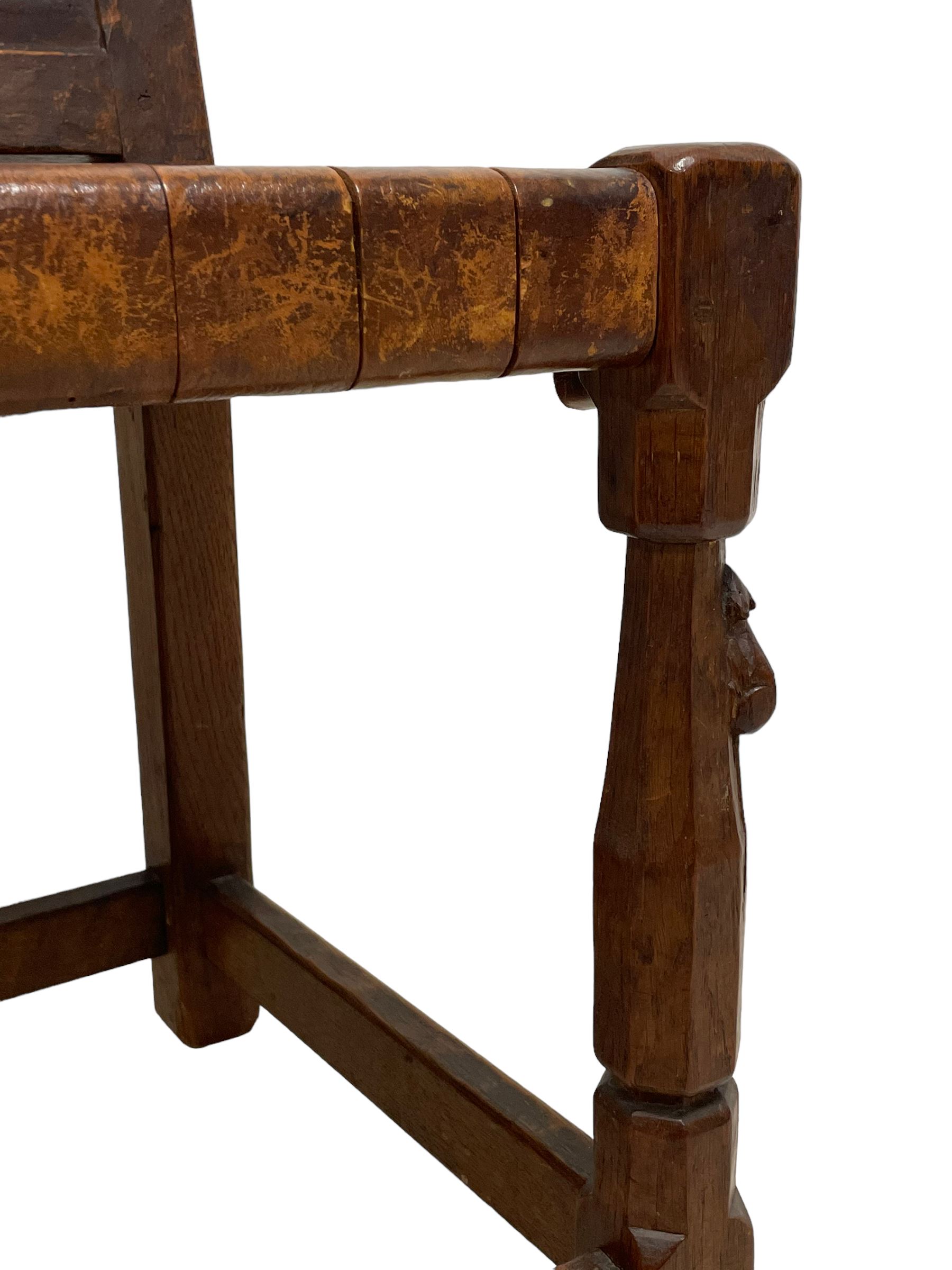 Mouseman - circa. 1930s set of six (4+2) oak dining chairs, panelled back carved with the Bagshawe family crest, the moto 'Forma Flos Fama Flatus' over an arm grasping a bugle-horn with ribbon tie and Yorkshire rose motif, adzed frame, leather lattice strap seat, on octagonal supports united by stretchers, two carvers and four side chairs, each carved with mouse signature, by Robert Thompson of Kilburn 

Provenance: Owned since manufacture by the Bagshawe family, descendants of the Staithes Group Artist Joseph Richard Bagshawe RBA (1870-1909).