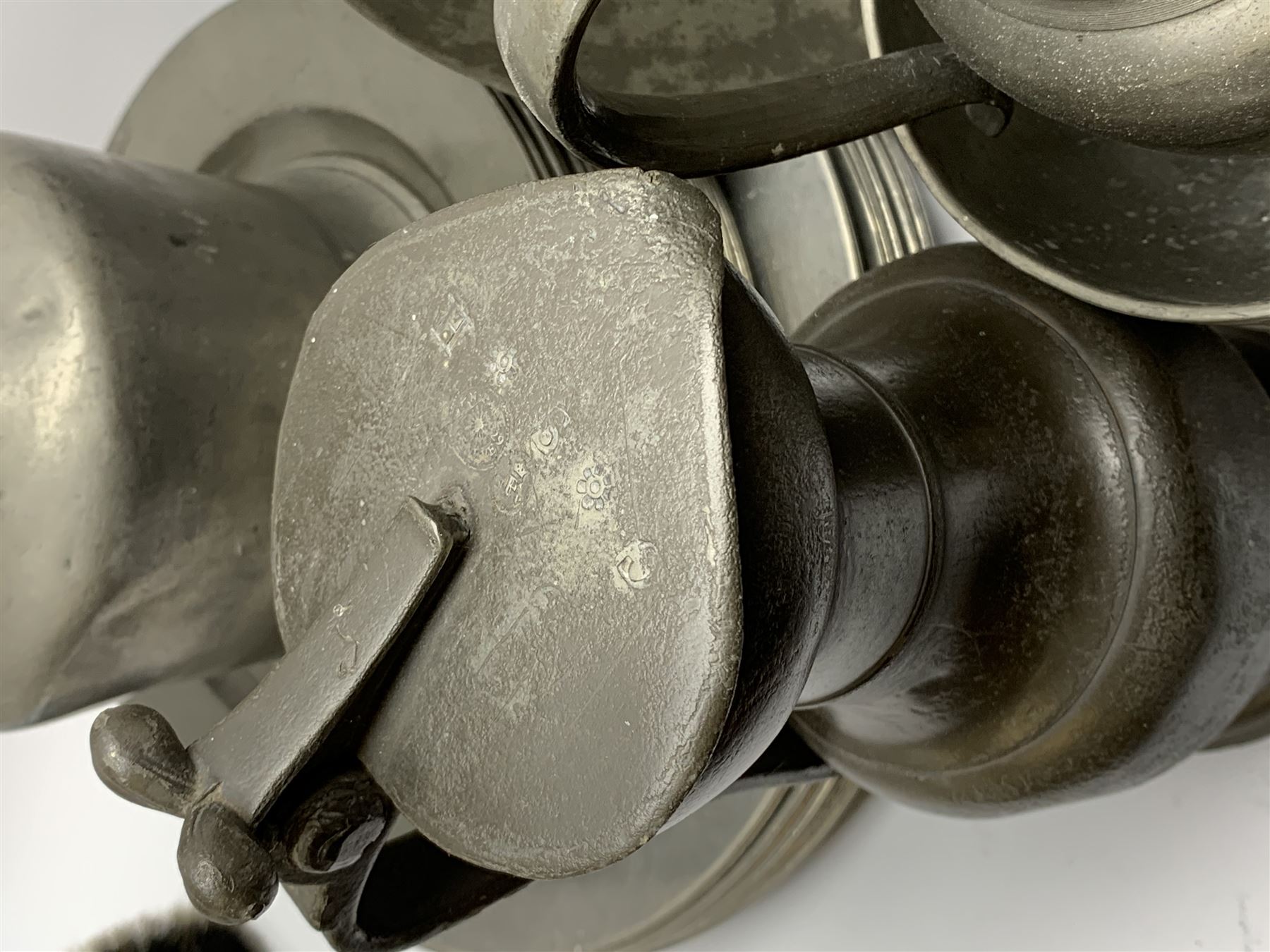 Collection of 18th and 19th century pewter, comprising two chargers, eight large plates, twenty six smaller plates, two bowls, three lidded measures, two jugs, tappit hen, and tankard, the plates with various marks and touch marks, including pseudo 'hallmarks', largest charger 37cm, large plates D30cm, smaller plates D24.5cm, tappit hen H26.5cm