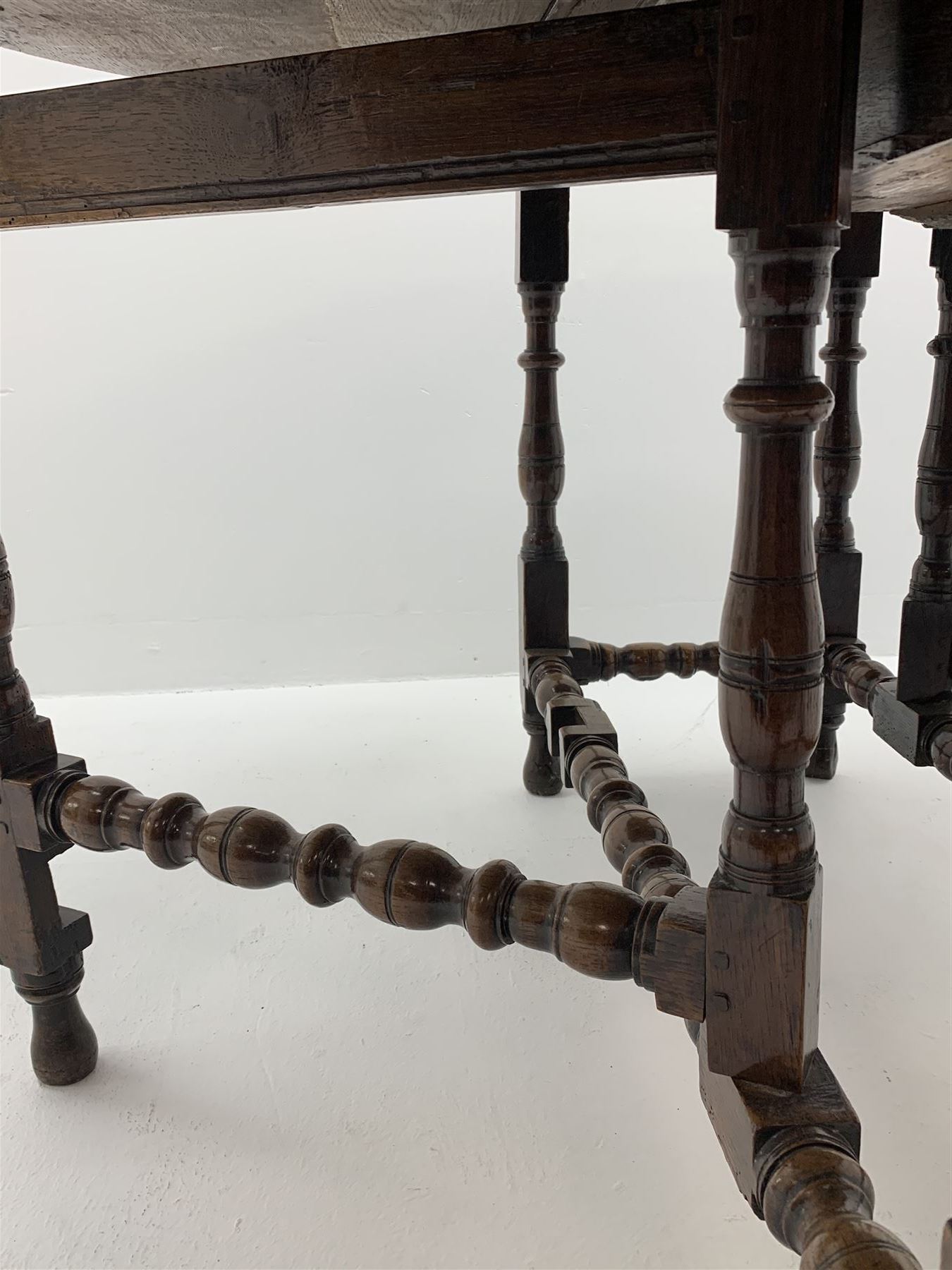 Late 17th century William & Mary oak drop leaf dining table, oval drop leaf top, single drawer to one end, gate action base, turned supports joined by bobbin turned stretchers, 121cm x 135cm, H75cm (open)