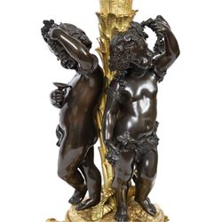 Louis XVI style gilt table lamp, the central column decorated with acanthus leaves, surrounded with three putti with vine leaf crowns, upon a circular base adorned with grape and vines, with shade, H64cm