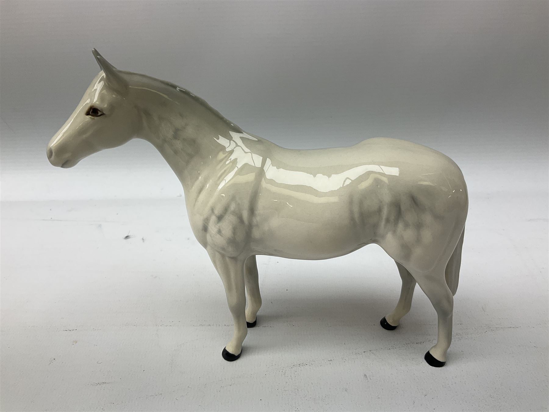 Collection of Beswick horses, including grey horse no.701, palomino foal no 836, grey stocky jogging mare no.855 etc, together two Royal Doulton horses, (8)