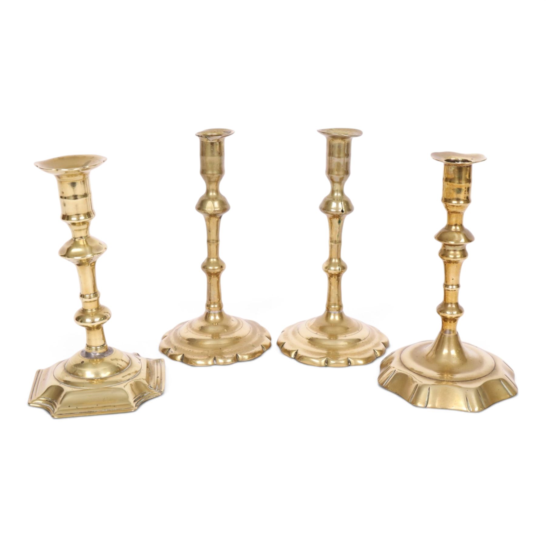 pair of 18th century brass candlesticks, each having slender knopped stems and scalloped petal base, together with two other brass candlesticks, H21cm