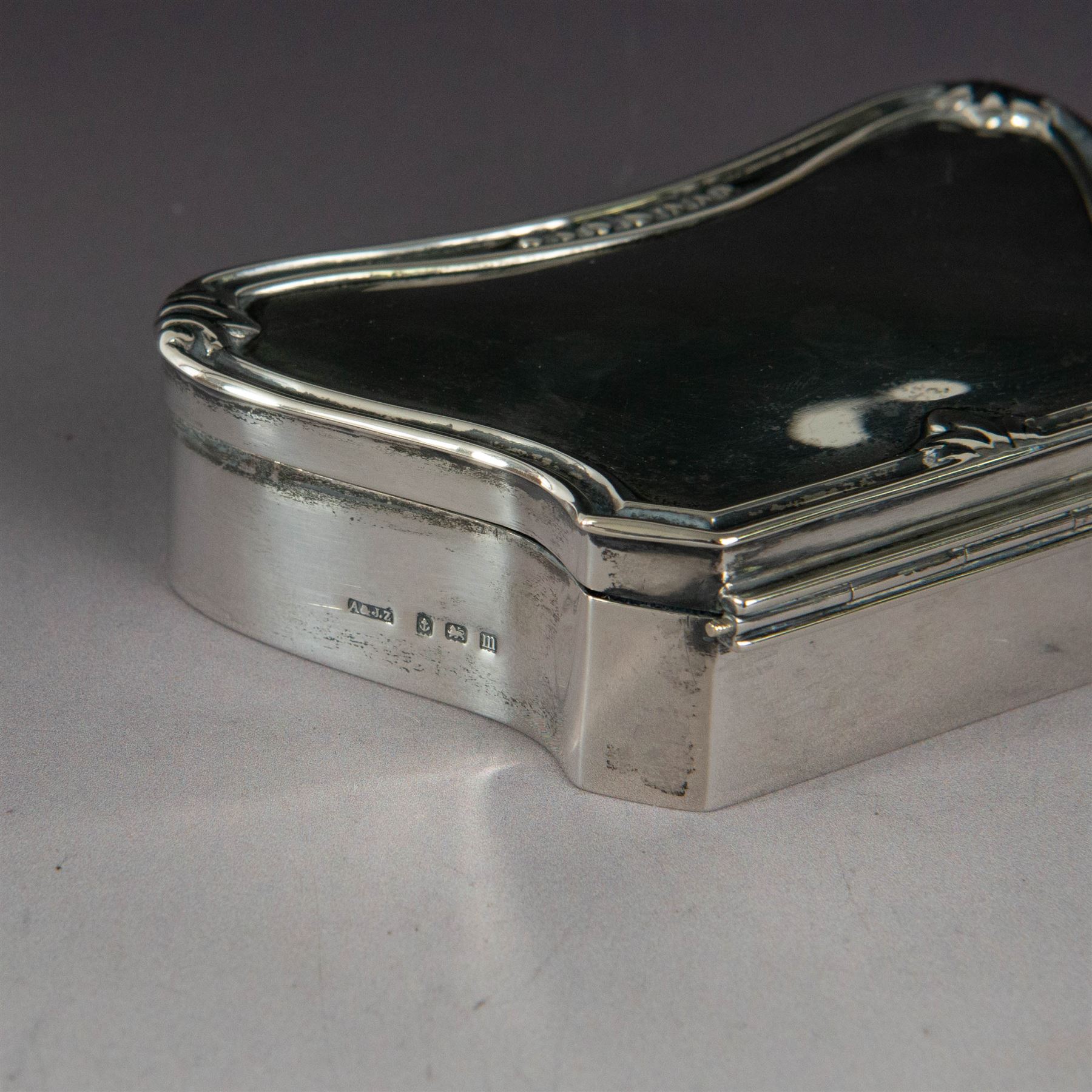 Early 20th century silver mounted jewellery box, with curved front and embossed palmette rim, opening to revel padded interior with weighted base, hallmarked A & J Zimmerman Ltd, Birmingham 1911, H3cm, W11cm