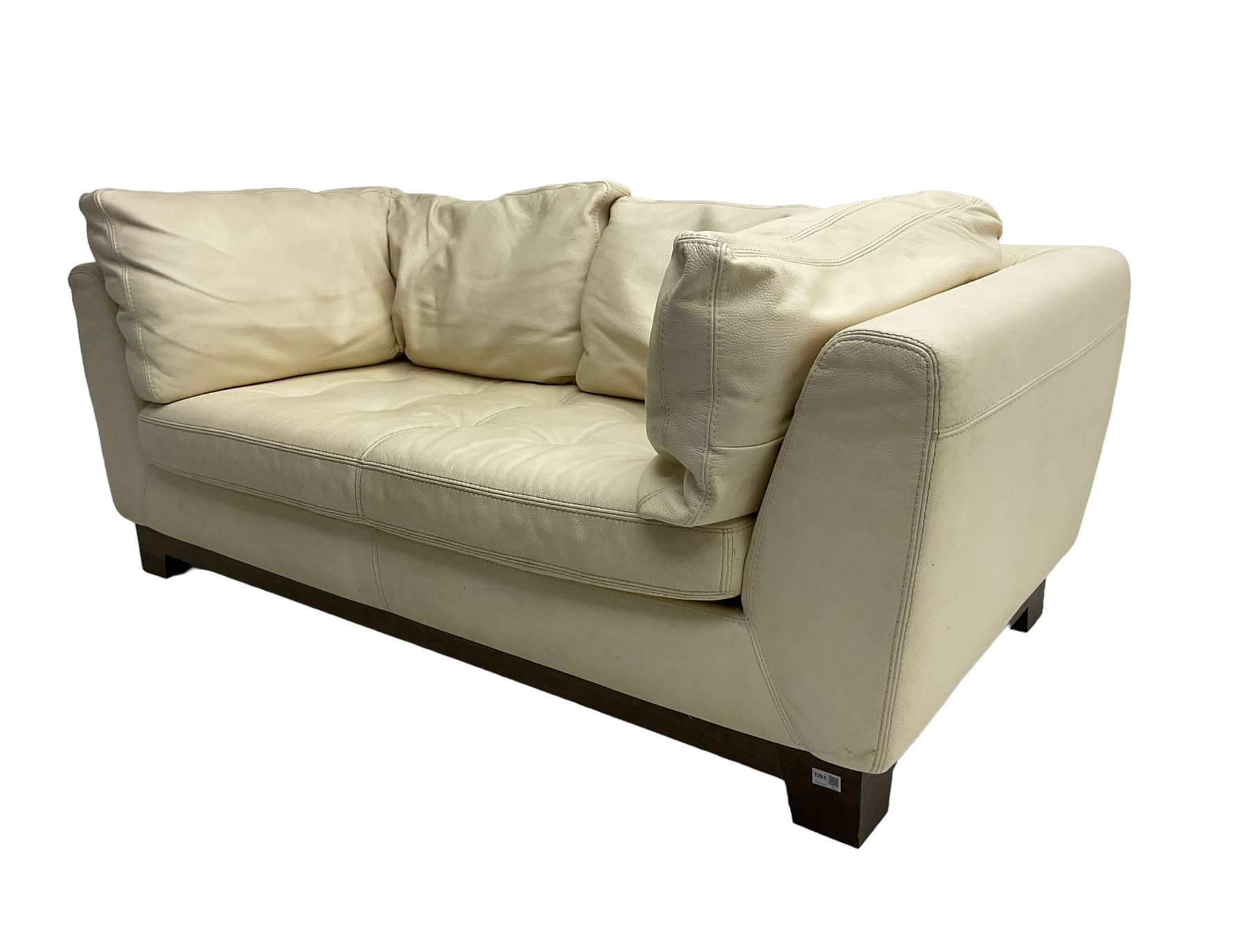 Roche-Bobois - two seat sofa, upholstered in ivory leather with buttoned seat cushions, raised on a stained beech base with bracket feet