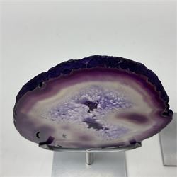 Pair of purple agate slices, polished with rough edges raised upon silvered metal stands, H23cm