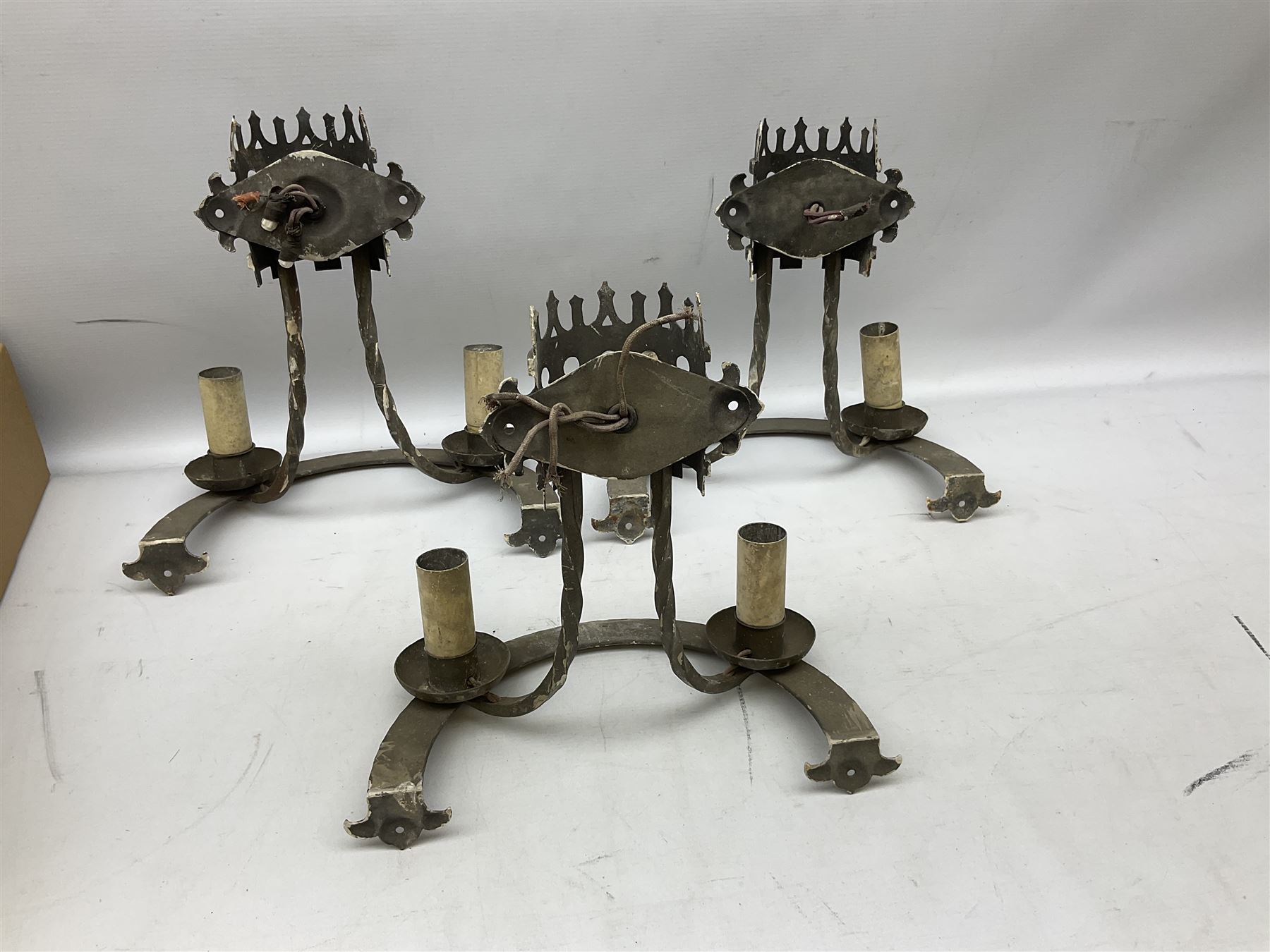 Gothic style iron chandelier with drip pans and twisted branches together with three matching twin wall sconces