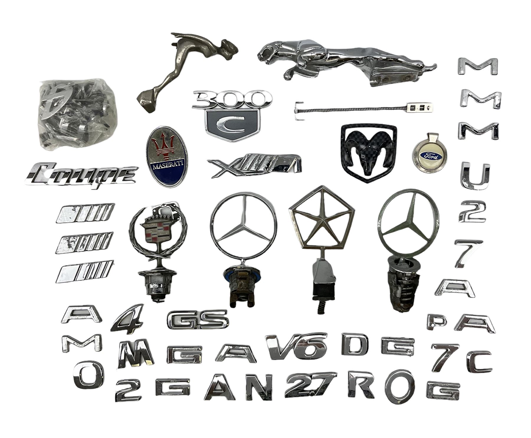 Nickel plated car mascot as a nude lady in a diving pose, similar to an A.E. Lejeune 'Speed Nymph', but marked 'N.L.C. Co. RegEd Des.'; chrome leaping Jaguar car mascot; and quantity of car model name letters, numbers and logos including Mercedes-Benz etc