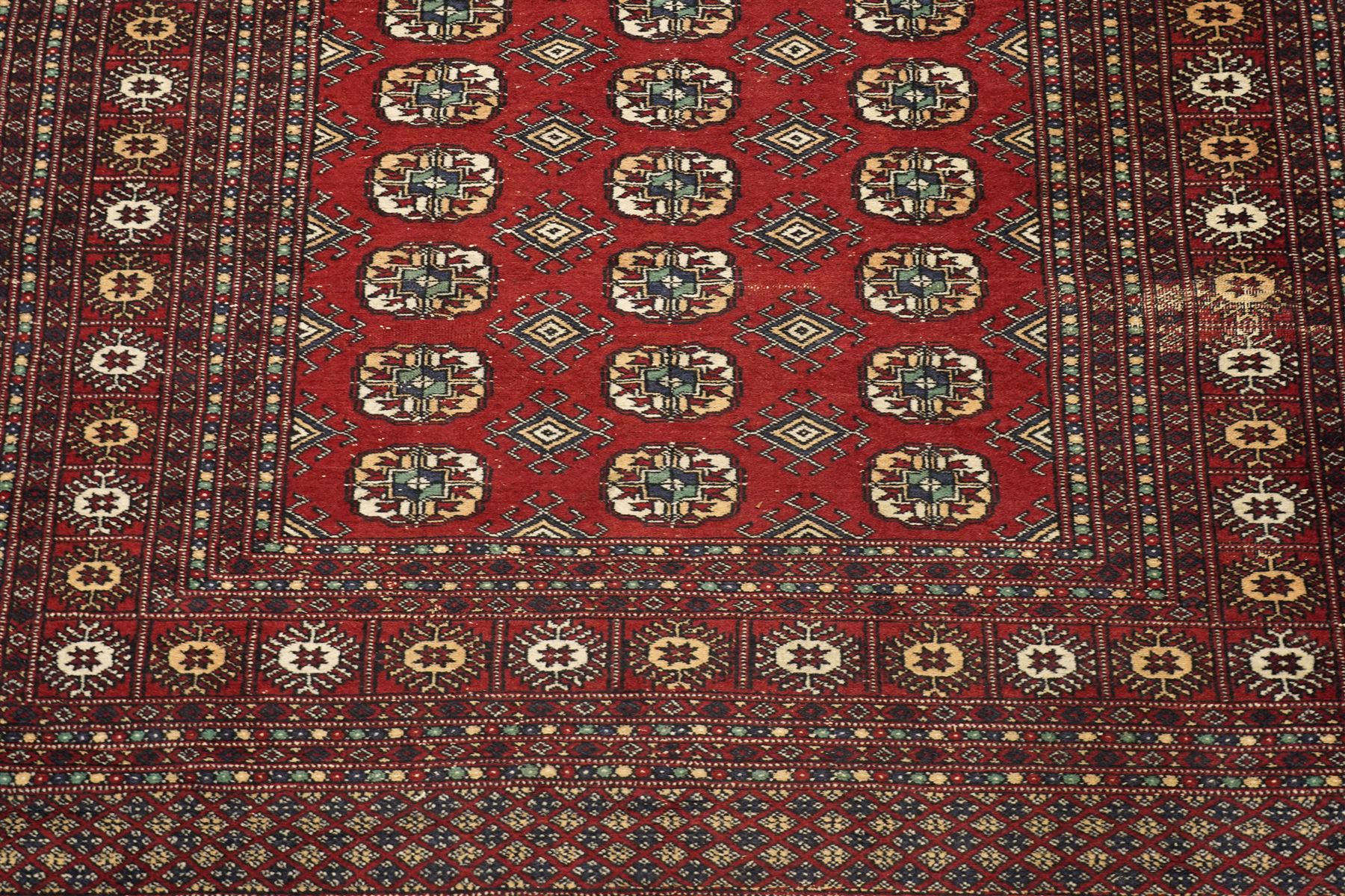 Two hand-knotted rugs, comprising Turkoman Ersari rug and Bokhara rug, Turkoman Ersari hand-knotted rug, terracotta ground with two rows of repeating octagonal guls interspersed with geometric motifs, enclosed by multiple geometric borders, fringed ends, H125cm, W93cm; Bokhara hand-knotted rug, madder red ground with three rows of repeating Tekke guls interspersed with geometric motifs, enclosed by multiple stylised floral and geometric borders, fringed ends, H188cm, W126cm