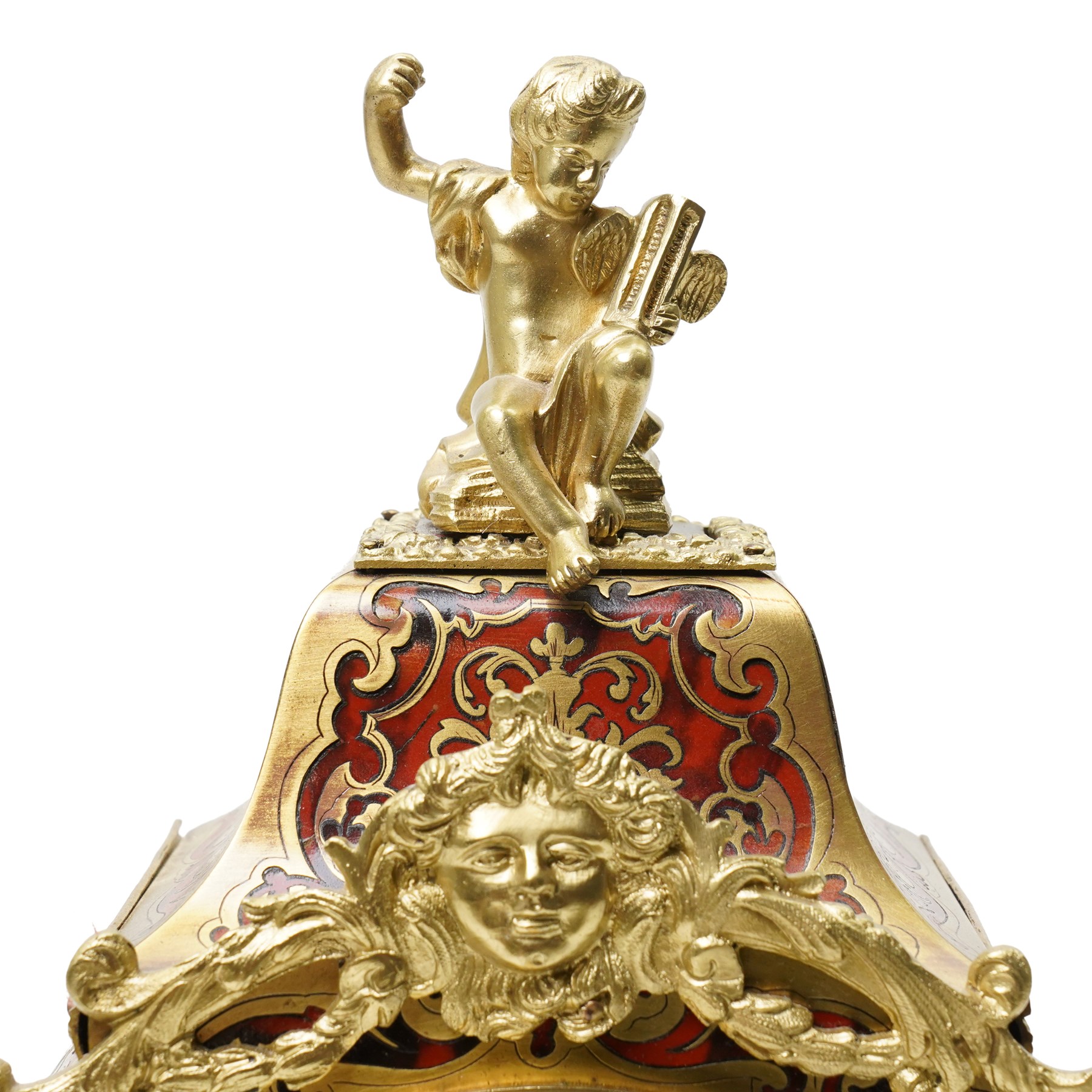 Rollin à Paris - 19th century French Louis XV style ormolu-mounted red tortoiseshell and brass Boulle-work mantel clock, surmounted by a seated musical putto above a waisted case applied with mask, rocaille, foliate and dolphin mounts, the gilt dial with white enamel Roman numeral cartouches, twin-train movement striking on a bell, signed and numbered 480, on four scrolling foliate feet