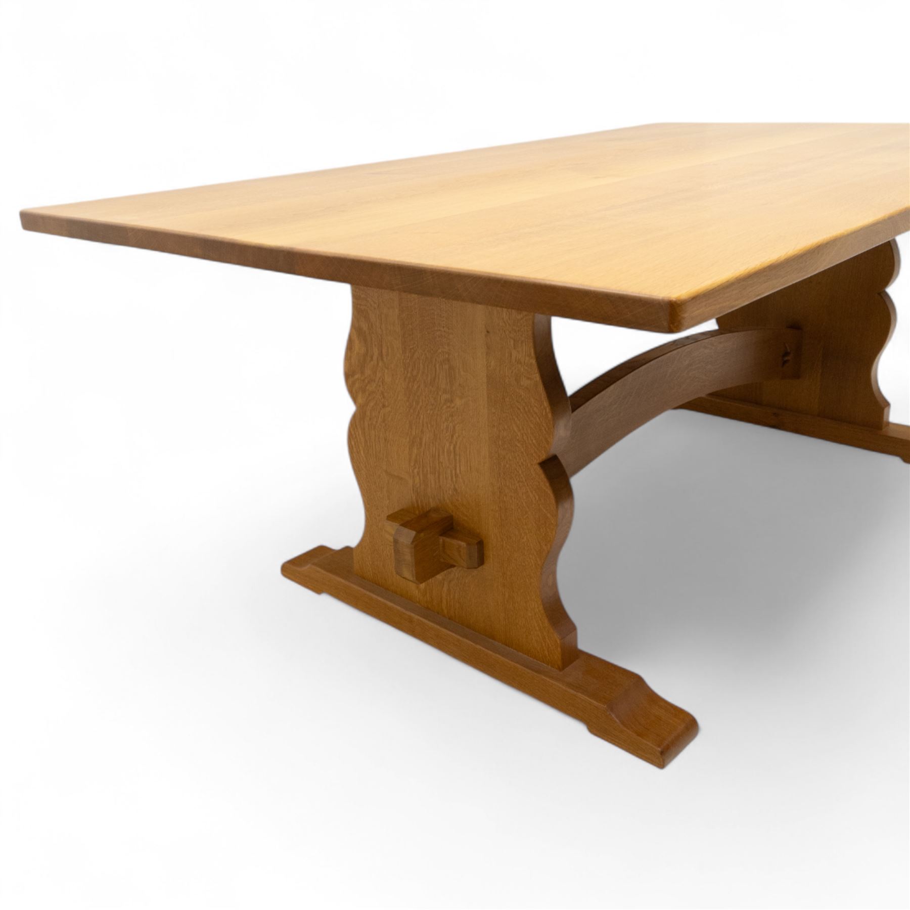 Unicornman - Yorkshire oak rectangular refectory style dining table by Coxwold cabinet maker Geoff Gell, rectangular top above trestle form base with broad scrolling outward outline, and heavy arched stretcher with Unicornman carved motif, traditional mortice and tenon pegged joints between the uprights