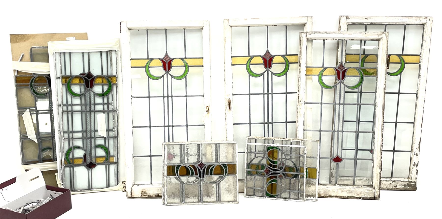 Collection of stained and leaded glass windows and panes, stylised floral design, various sizes, the largest window measuring 55cm x 112cm (including wooden frame)