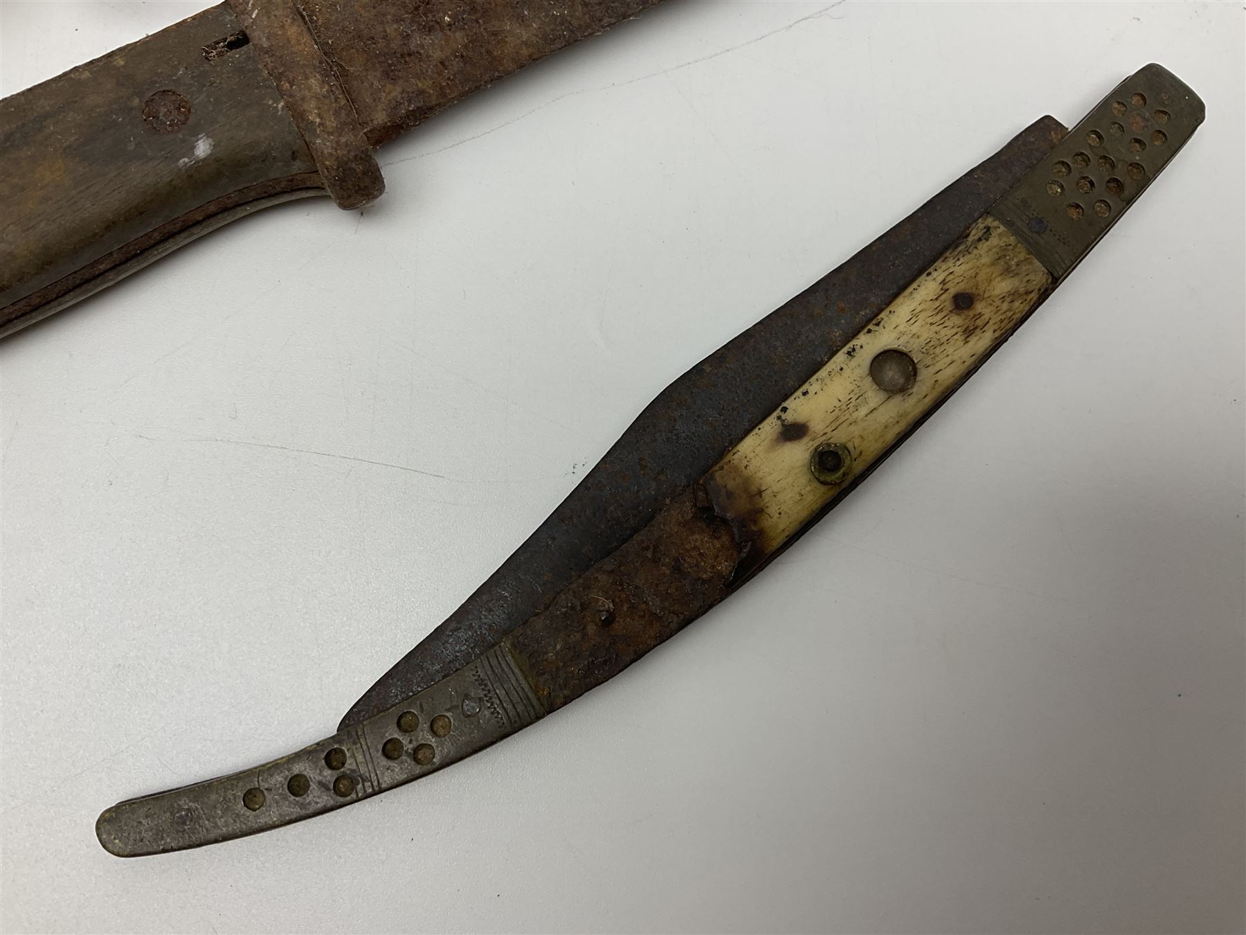 19th century continental folding knife with 15.5cm single edged blade, the pierced brass and iron handle with remains of horn grips L21.5cm overall closed; turned horn handled knife with foliate engraved blade; battlefield relic German 1884/98 knife bayonet; iron spear head; leather covered swagger stick; and two-piece gun cleaning rod