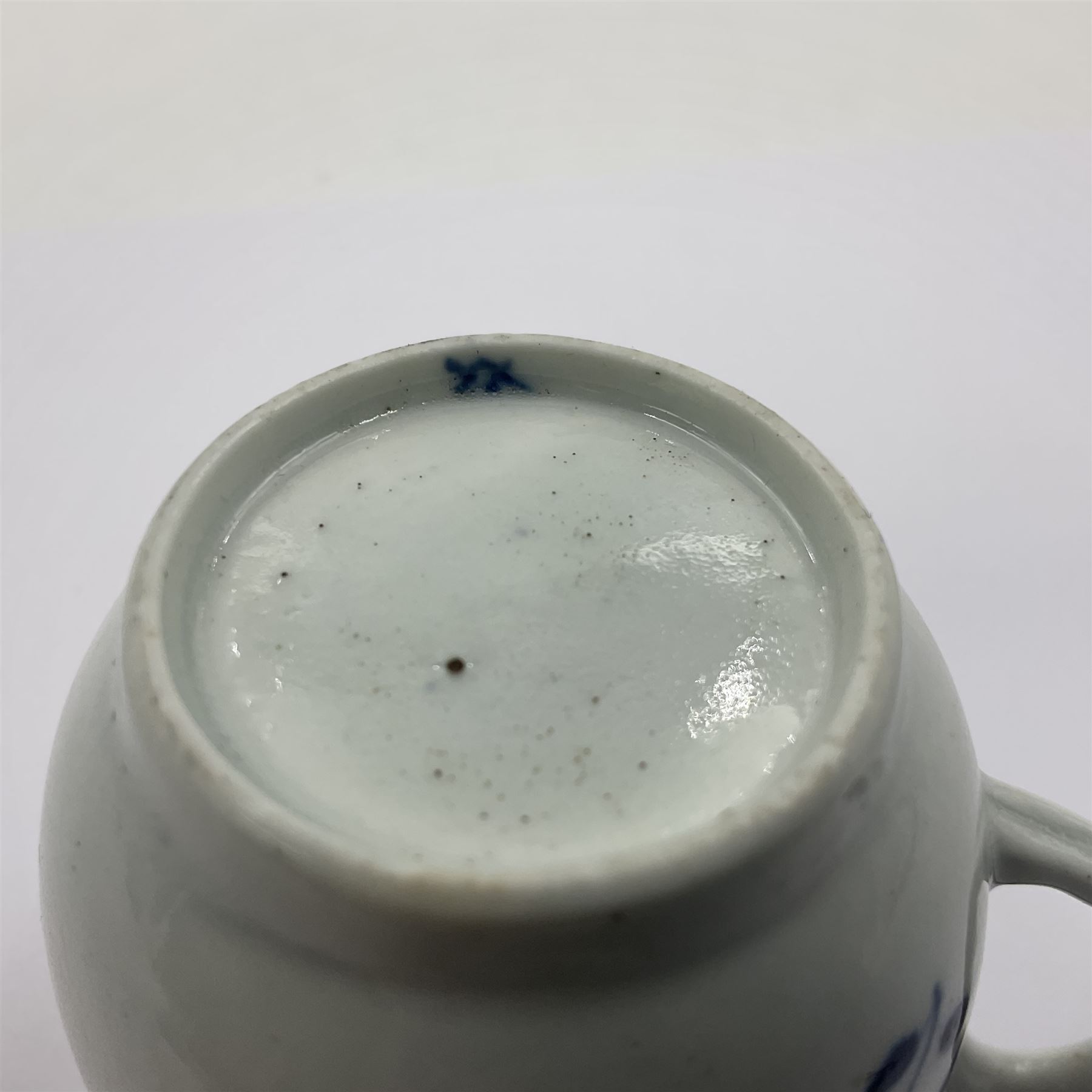 Two 18th century Worcester porcelain coffee cups, the first example decorated in the Plantation pattern, circa 1754, the second decorated in the Mansfield pattern, circa 1760, with workman's mark beneath, each approximately H5.5cm