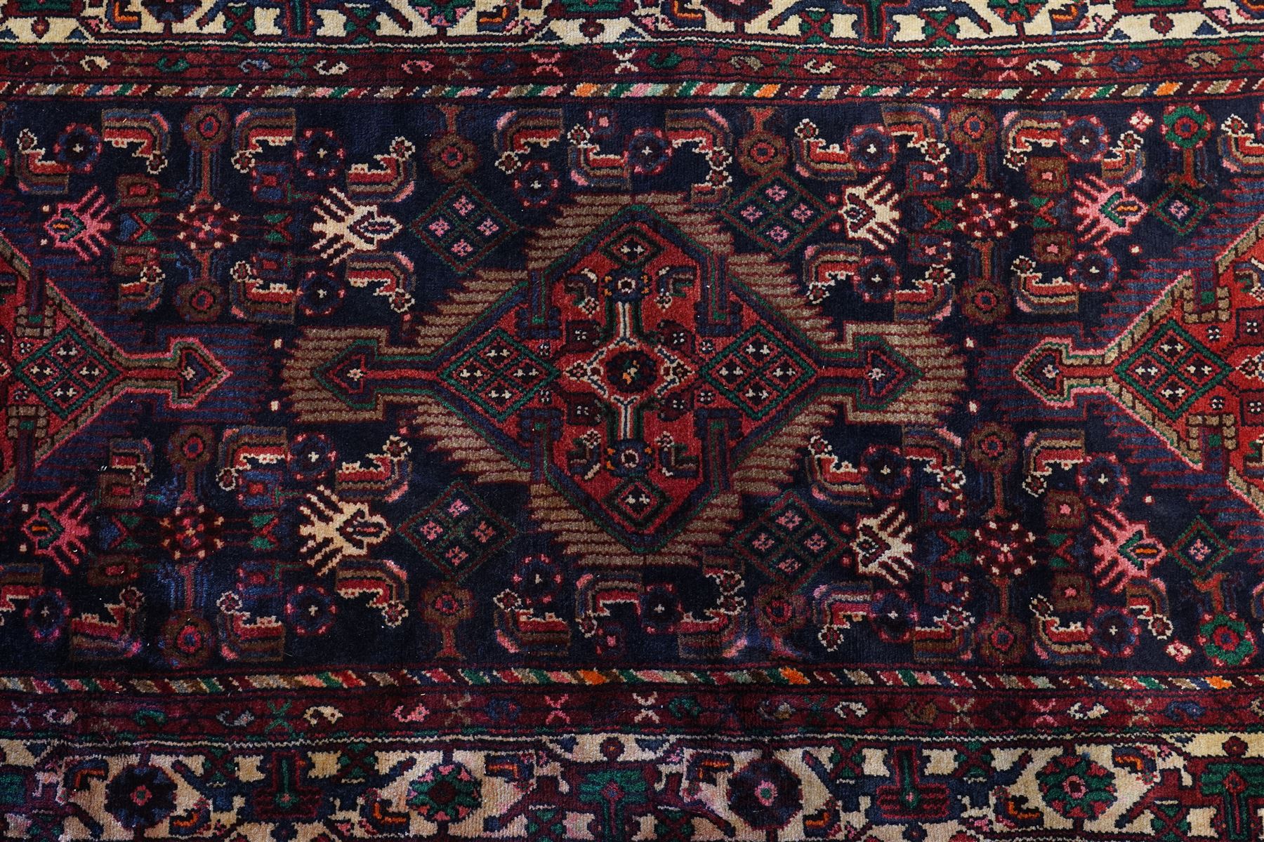 North West Persian Malayer hand-knotted runner, indigo field with vertical lozenge medallions surrounded by angular floral sprays, rosettes, and stylized palmettes, field enclosed by serrated ivory spandrels incorporating polychrome floral decoration, framed by ivory ground main border of stylized flowers and hooked devices, flanked by reciprocal guard stripes, cotton fringe ends 